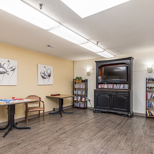 Activity room with books and a TV at Willowbrook Post Acute